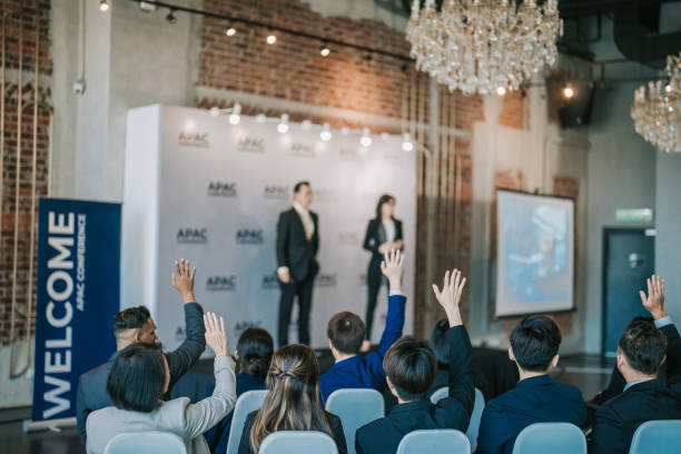istock back view Active Asian Seminar participant raise hands during business conference sharing session 1654537087