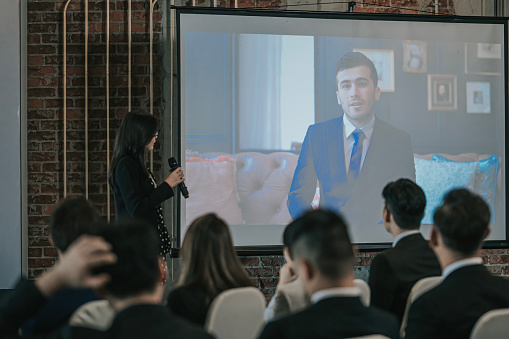 Asian Business people Video Conference Call projector screen in Meeting Room. Diverse Team of Creative Entrepreneurs at seminar Discussion. Specialists work in Digital e-Commerce Startup