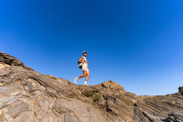 istock tourist girl with a backpack on her back climbs the mountain in summer 1654547039