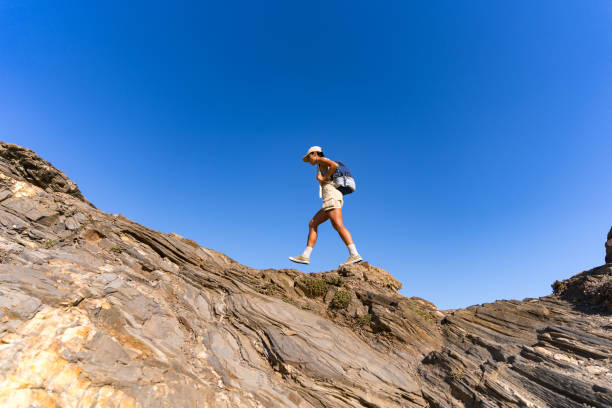istock tourist girl with a backpack on her back climbs the mountain in summer 1654549281