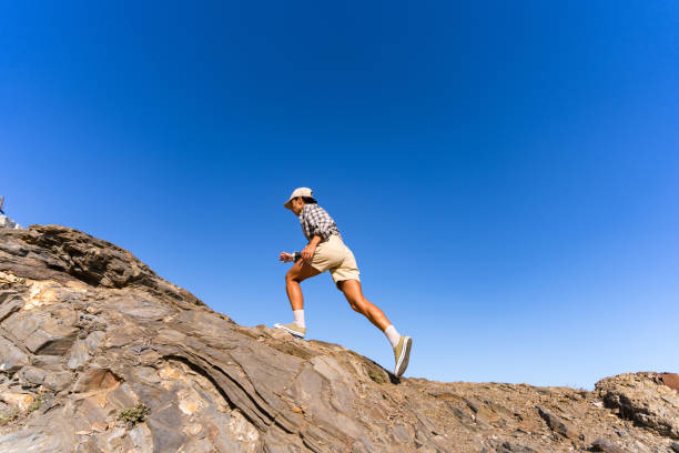 istock tourist girl with a backpack on her back climbs the mountain in summer 1654551487