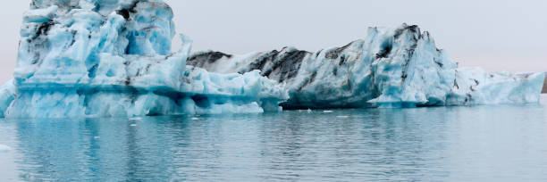 un iceberg en islandia. un iceberg que desemboca en la laguna de jokulsarlon, separado del frente del glaciar. - natural disaster glacier iceberg melting fotografías e imágenes de stock