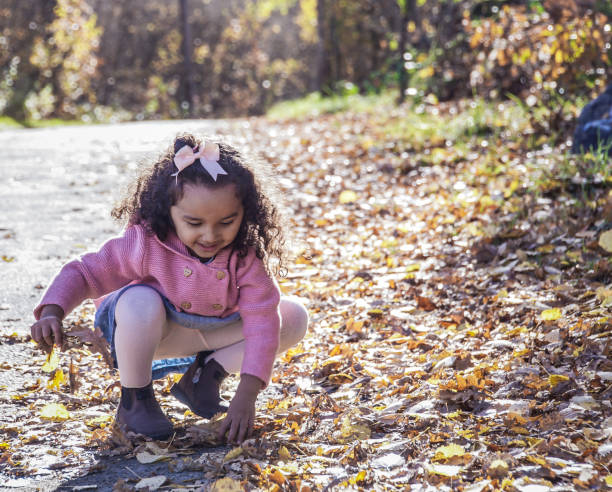 istock Girl playing with leaves during autumn 1654572806