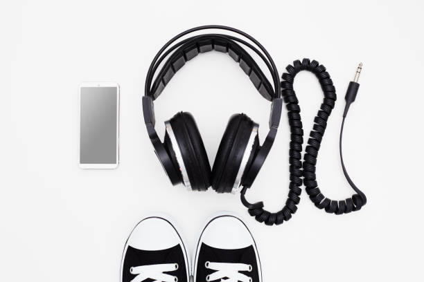 istock Smart phone mockup with headphones and sneakers on white background 1654650430