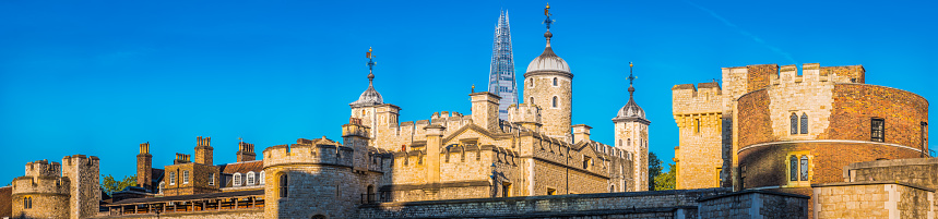 Panoramic view along the historic battlements of the Tower of London overlooked by the futuristic spire of The Shard.