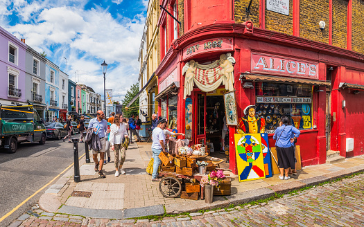 People shopping and browsing in the colourful Portobello Market and antique shops in the heart of London, UK.