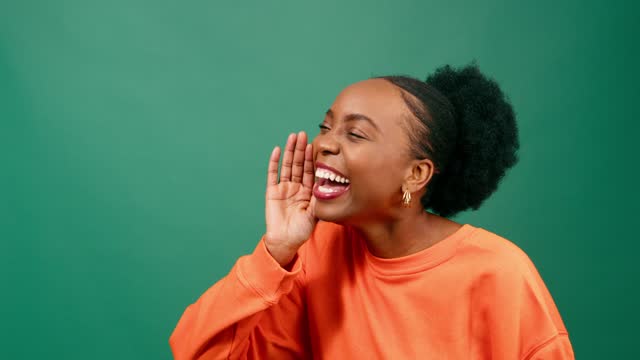Young Black woman raises hand, yells excitedly to come over green background