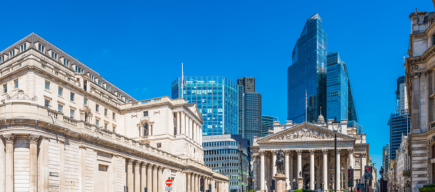 The Bank of England in the heart of the City of London Financial District overlooked by modern skyscrapers.