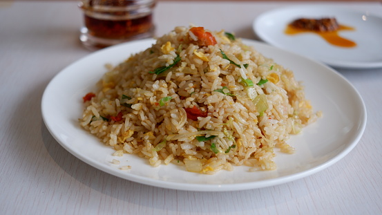 Yang Chow fried rice on a white plate with chilli oil. Chinese food.