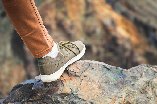 Close-up on a woman's foot in a sneaker in nature. Walk in comfortable shoes outdoor.