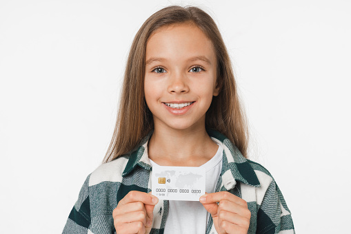 Closeup cropped caucasian preteen teenage girl showing credit card for cashback transactions loan debt e-learning e-commerce isolated in white background