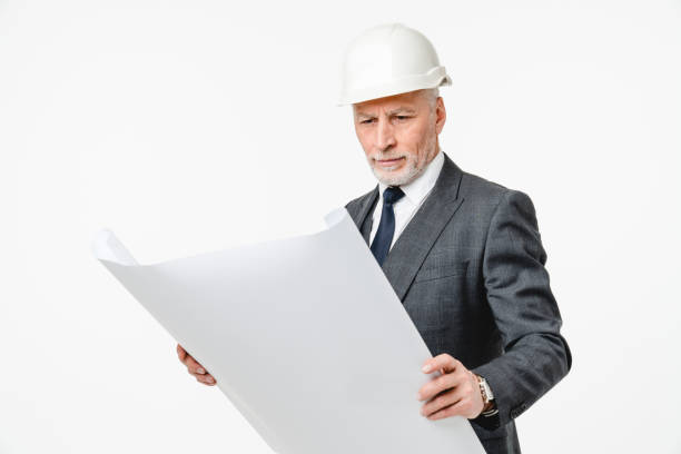 istock Senior construction worker architect engineer in formal suit and hardhat with architectural plan for building real estate isolated in white background 1654729357