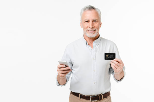 istock Caucasian senior middle-aged businessman grandfather freelancer using mobile banking e-commerce application for credit card shopping online isolated in white background 1654731446