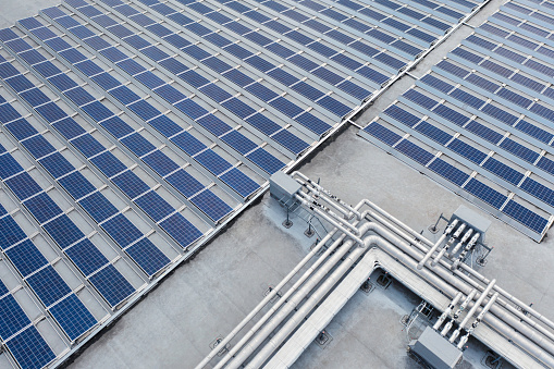 Pipes, cables and solar panels on an industrial building roof.
