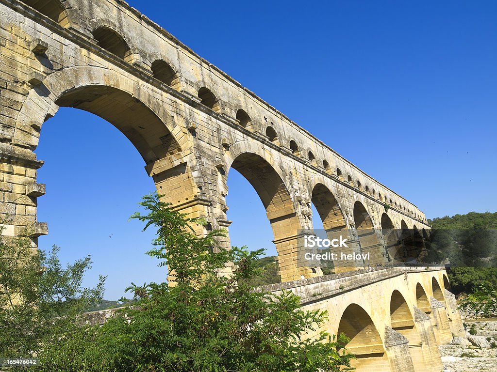 Pont du Gard aqueduct built 2000 years ago to transport water across the river Gardon. It is built without mortar, and some stones weigh up to 6 tons.One of the biggest attractions in France. Antique Stock Photo