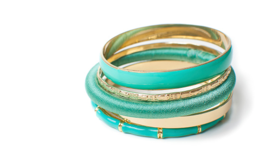 jewelry, five fashion elegant bright gold and green women's bracelets, isolated, close-up