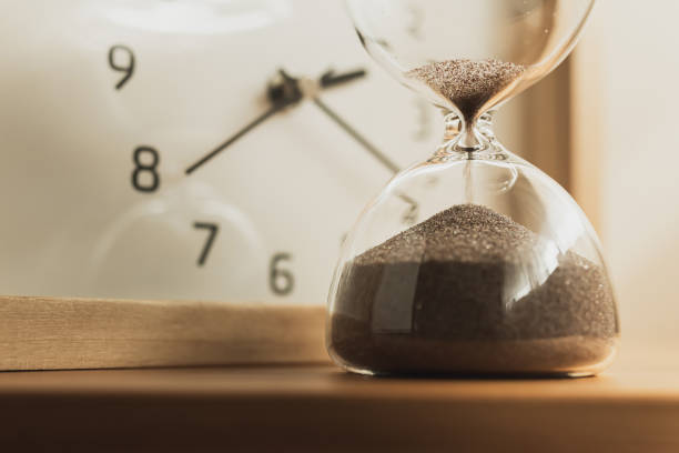 istock Clock and hourglass. The flow of time. 1654780250