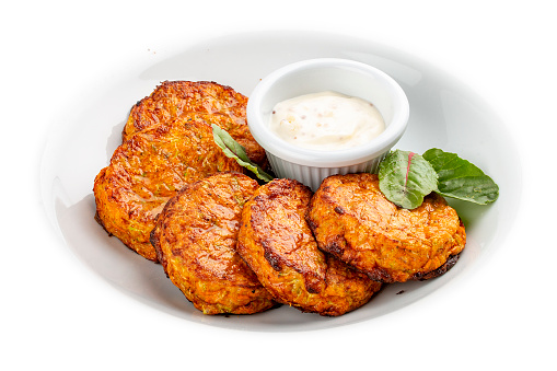 Pumpkin cutlets with white sauce. Vegetarian dish. Isolated image on a white background.