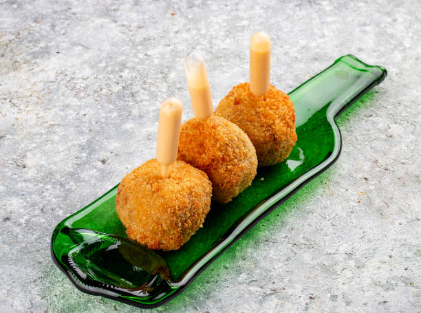 istock Cheese balls deep-fried with white sauce on a decorative plate. Isolated image on a gray background. 1654798610