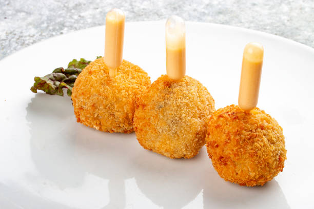 Cheese balls deep-fried with white sauce. Isolated image on a white background.