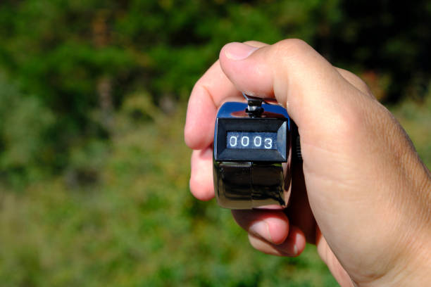 istock Manual mechanical counter for accurate counting in your hand green background. 1654817123
