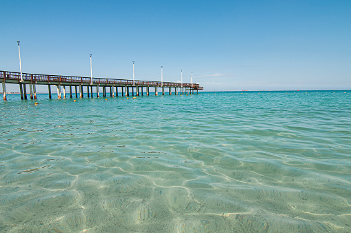 view of the pier in El Coromuel beach, on a beautiful and sunny summer morning with clear blue sky and the transparent sea of ​​Cortes. La Paz Baja, seascape of Mexicoiew of the pier in El Coromuel beach, on a beautiful and sunny summer morning with clear blue sky and the transparent sea of ​​Cortes. La Paz Baja, seascape of Mexico