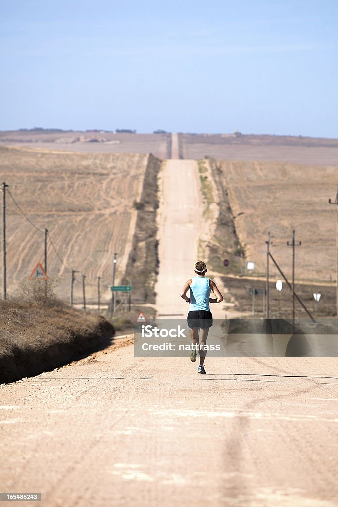 Elite mujer atleta corriendo en un camino de grava - Foto de stock de Adulto libre de derechos