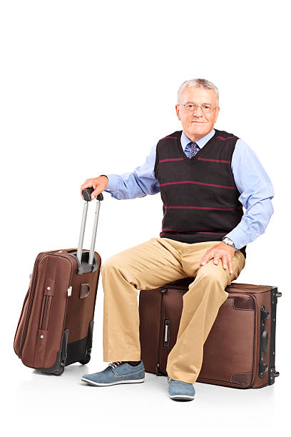 istock Mature man resting seated on a travel bag 165486268