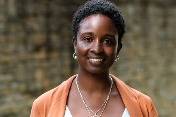 istock A black smiling woman is looking at camera outside. 1654869994