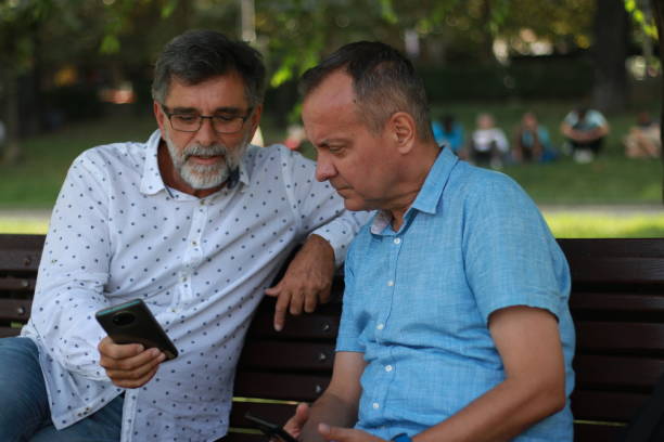 istock Two senior businessmen sitting on bench and talking of work 1654876496