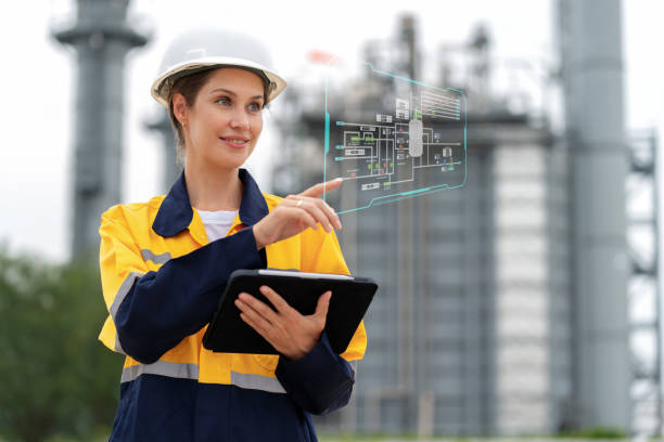 Production engineer of industrial innovation with digital tablet. Standing at electric power plant and looking at plant layout factory on the graphic screen with high technology. Intelligence drive efficiency and continuous improvement. Production engineer of industrial innovation with digital tablet. Standing at electric power plant and looking at plant layout factory on the graphic screen with high technology. Intelligence drive efficiency and continuous improvement. project manager remote stock pictures, royalty-free photos & images