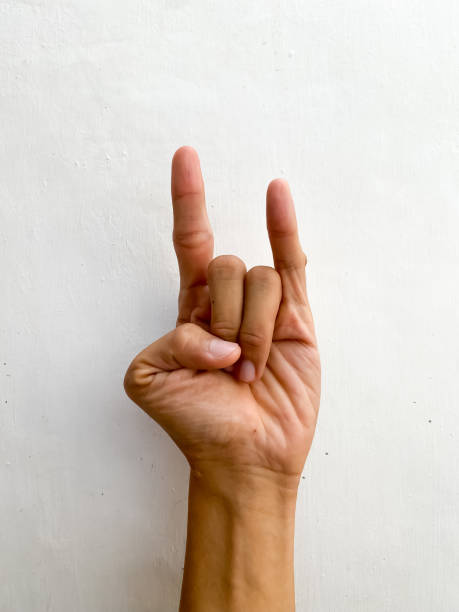 istock Hand showing fingers over isolated white background gesturing horns expression doing heavy metal symbol with fingers. Concept for heavy metal, death music, demon, satanic, and darkness. 1654894493