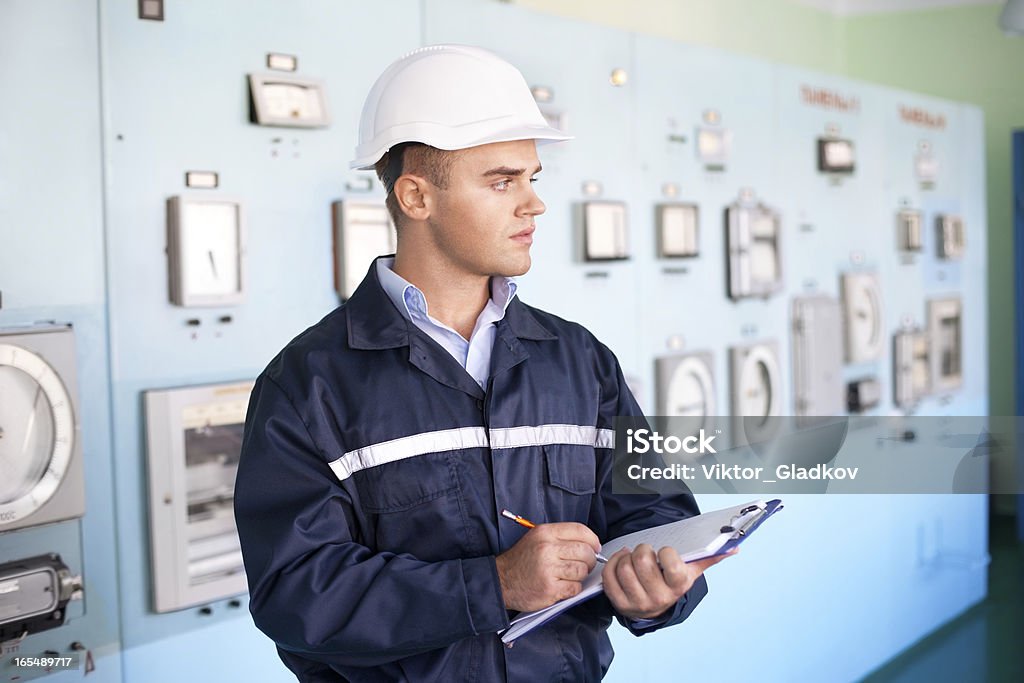 Joven Ingeniero tomando notas en la sala de control - Foto de stock de Accesorio de cabeza libre de derechos