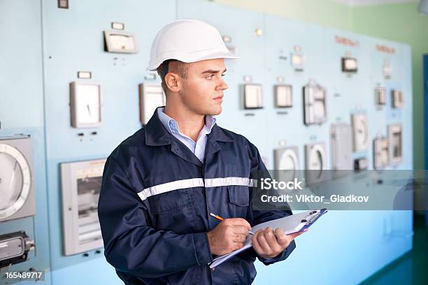 Joven Ingeniero Tomando Notas En La Sala De Control Foto de stock y más banco de imágenes de Accesorio de cabeza