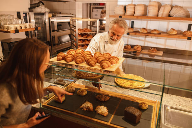 istock Caucasian Baker Attending A Young Female Costumer At The Bakery 1654901432