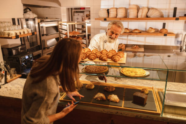 istock Caucasian Baker Attending A Young Female Costumer At The Bakery 1654901564