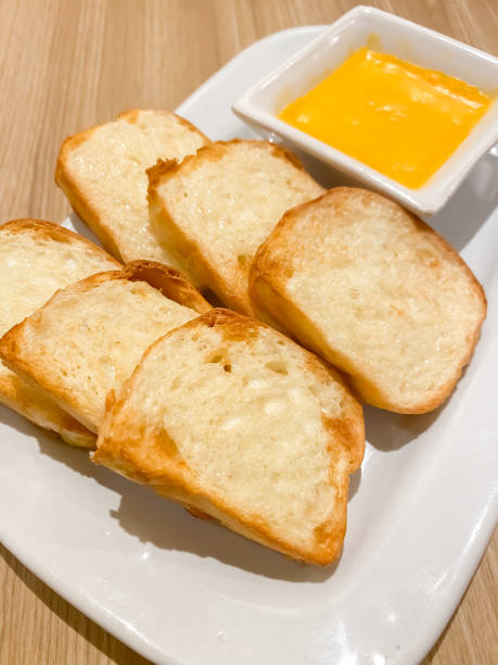 istock Freshly cooked butter bread and ready to serve on white plate with wooden table backgrounds. This food is very tasty and loved by many people for breakfast menu in the morning with a cup of hot black coffee or tea. 1654906783