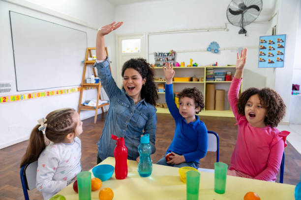 istock Happy teacher having fun with her students during break time while enjoying a snack and drink 1654909701