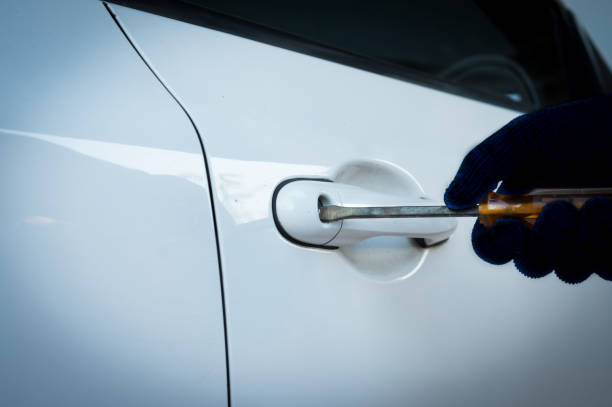istock Thief steals car breaks door lock with screwdriver. 1654910376