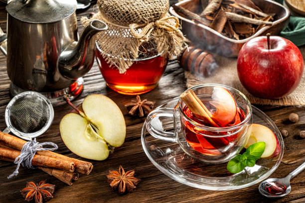 vista de perto de alto ângulo do chá de maçã quente com infusão de paus de canela em uma xícara em uma mesa rústica - stevia tea herbal tea herb - fotografias e filmes do acervo
