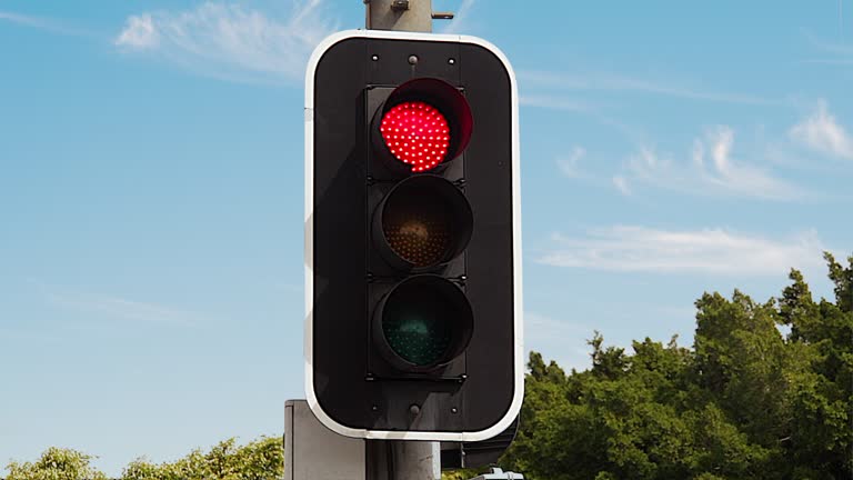 Traffic light changes from green to red against a beautiful clear blue sky