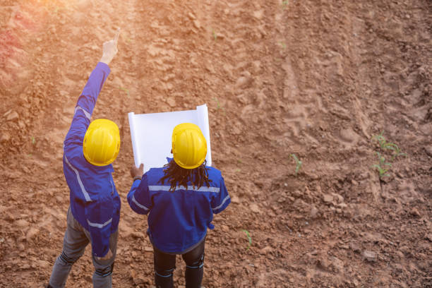 istock engineer land surveryor teamwork looking inspecting mark contruction site for building project with floor plan 1654916668