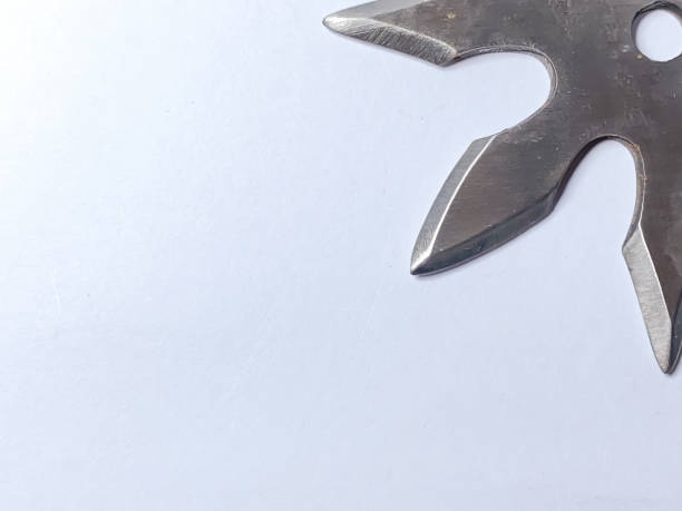 istock Shuriken is a sharp throwing weapon of ninjas. Weapons made from metal with a shape like a star or pinwheel that has a pointed tip. 1654919252