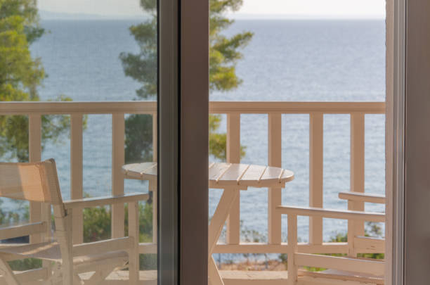 istock Loggia with table and chairs overlooking the summer seascape. View from the window. 1654920233