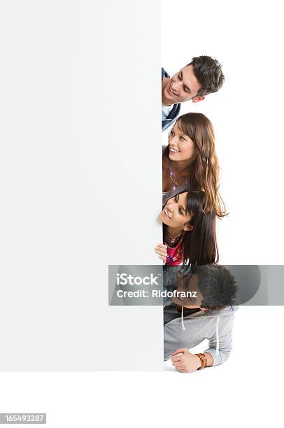 Group Of Friends Peeking At A Blank Placecard Stock Photo - Download Image Now - Group Of People, Teenager, Young Adult