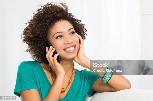 Smiling Woman On A White Couch Talking On The Phone Stock Photo - Download Image Now