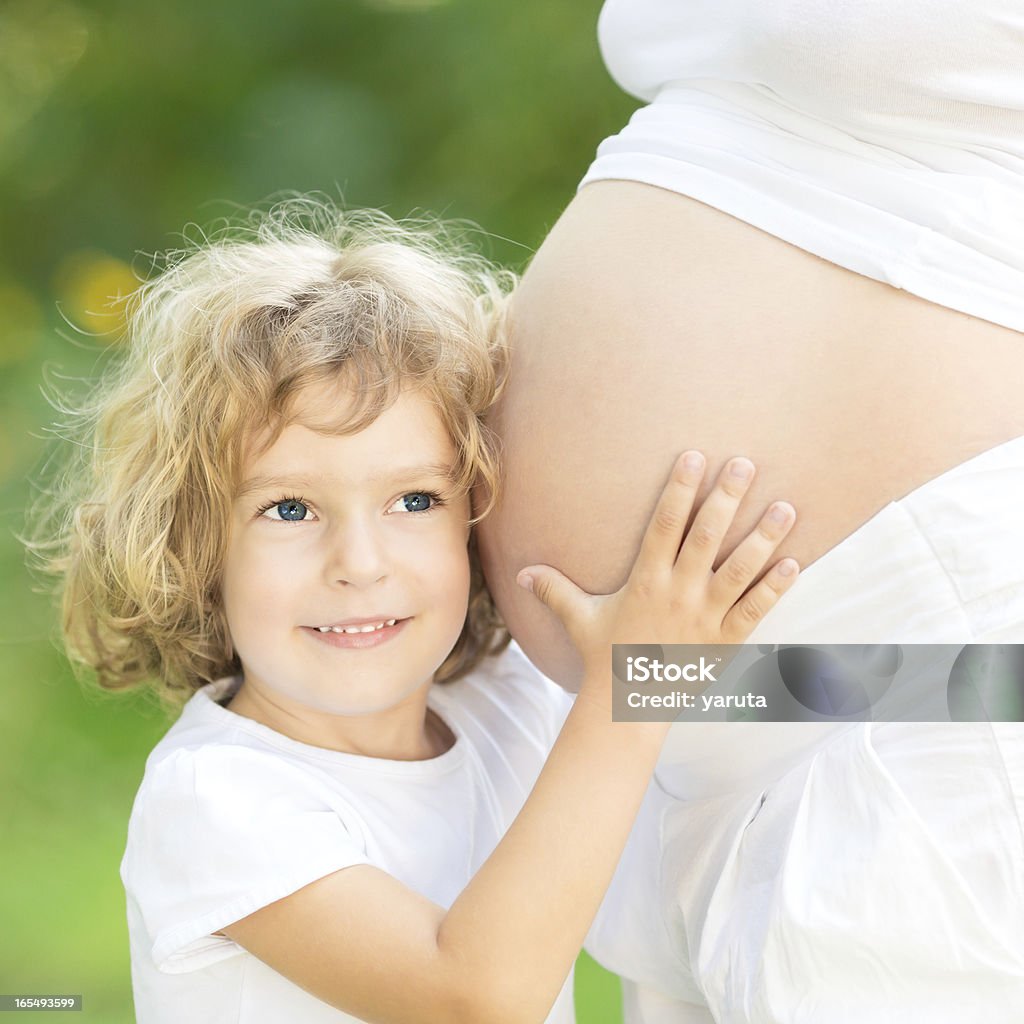 Criança segurando a barriga da Mãe grávida - Foto de stock de Abdome royalty-free