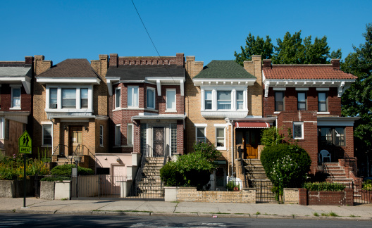 This is a horizontal, color photograph of brick homes in the Astoria neighborhood of Queens, New York. 