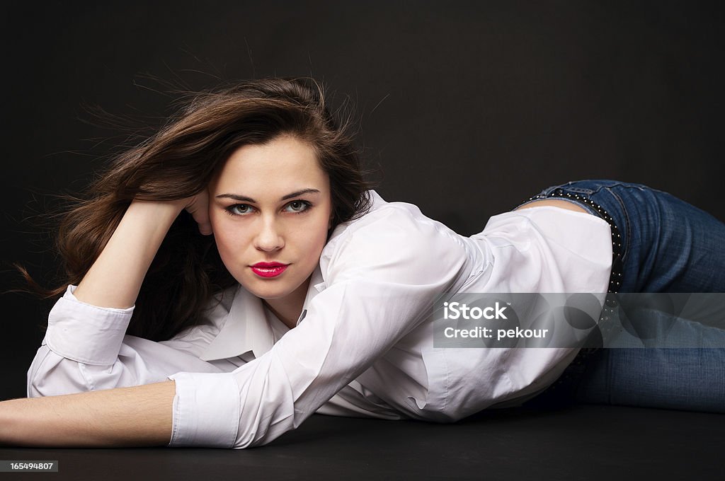Retrato de hermosa mujer joven en pantalones y camisa lying - Foto de stock de Acostado libre de derechos