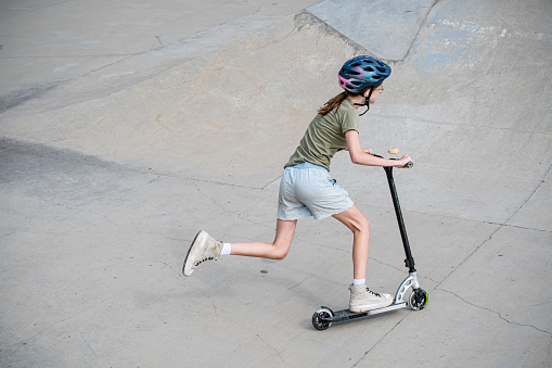 With boundless energy and determination, this 13-year-old scooter enthusiast conquers the skate park, epitomizing the essence of youthful freedom and excitement.